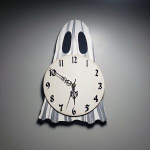 A ghost-shaped analog clock featuring a hand-painted ghost design based on Flukelady's popular sheet ghosts.